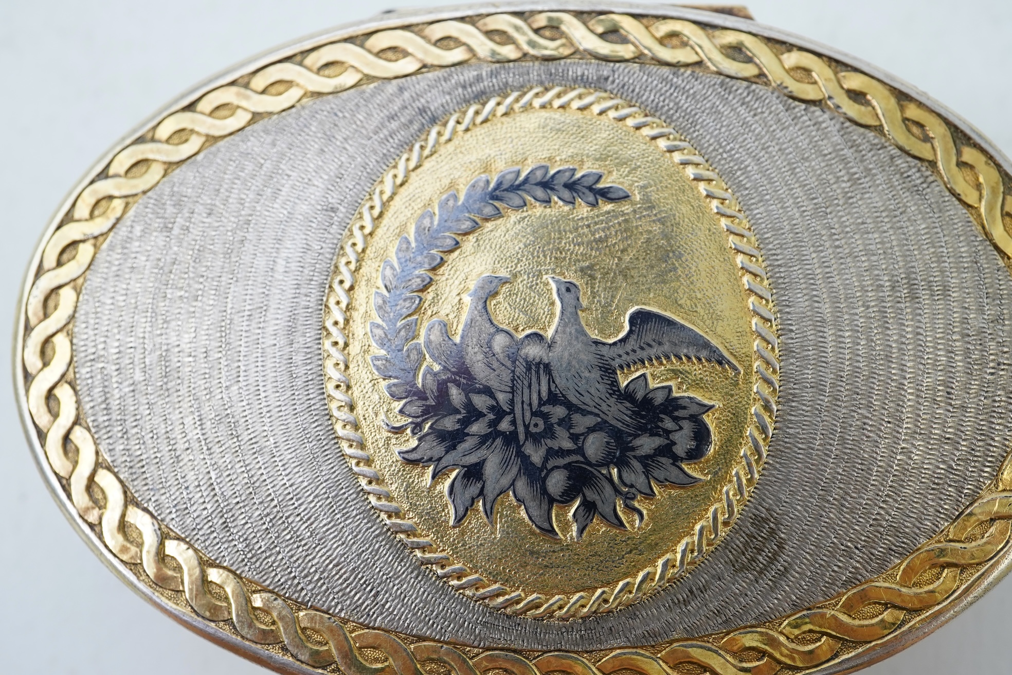 A 19th century Swiss? parcel gilt white metal oval snuff box with hinged cover